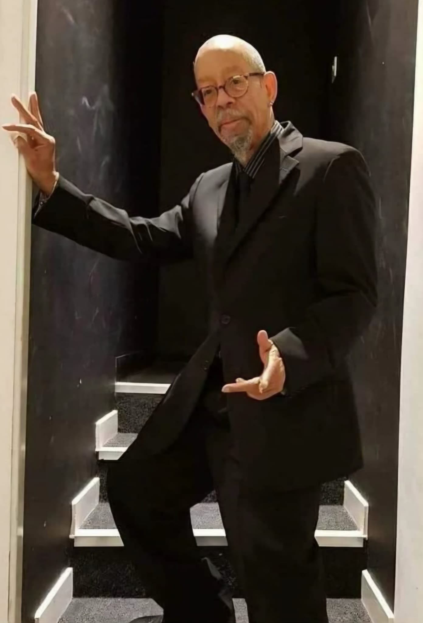Arthur Miles in a black suit and glasses, leaning on a doorway on the Soulfully Yours tour, 2023
